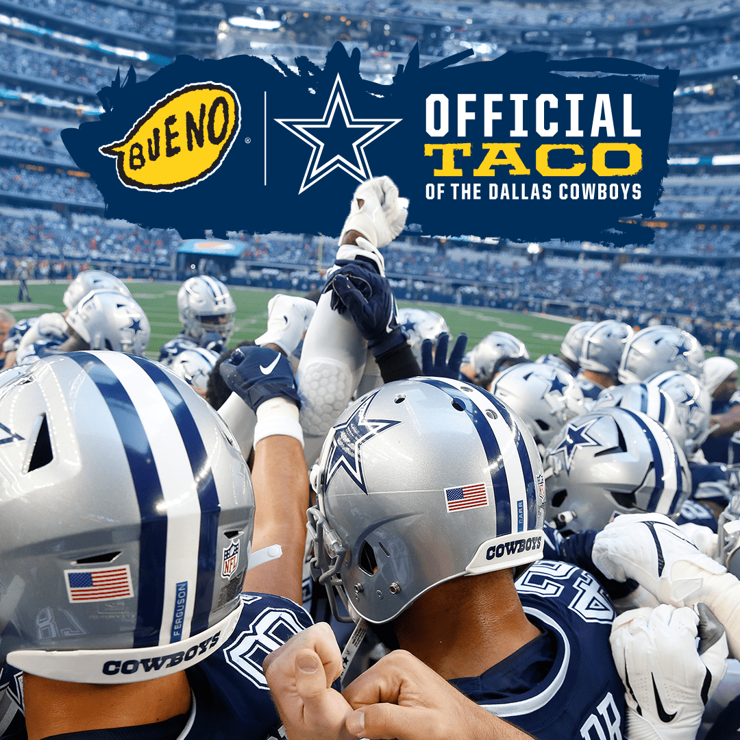 A huddle of Dallas Cowboys football players on the field, wearing silver helmets. A blue banner above shows the Taco Bueno logo next to the Cowboys star, with the phrase 'Official Taco of the Dallas Cowboys'.