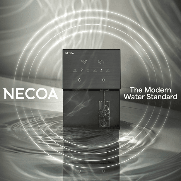 A sleek, dark gray NECOA water dispenser sitting on a watery surface with circular light waves emanating from it, featuring a glass containing ice cubes being filled with water.