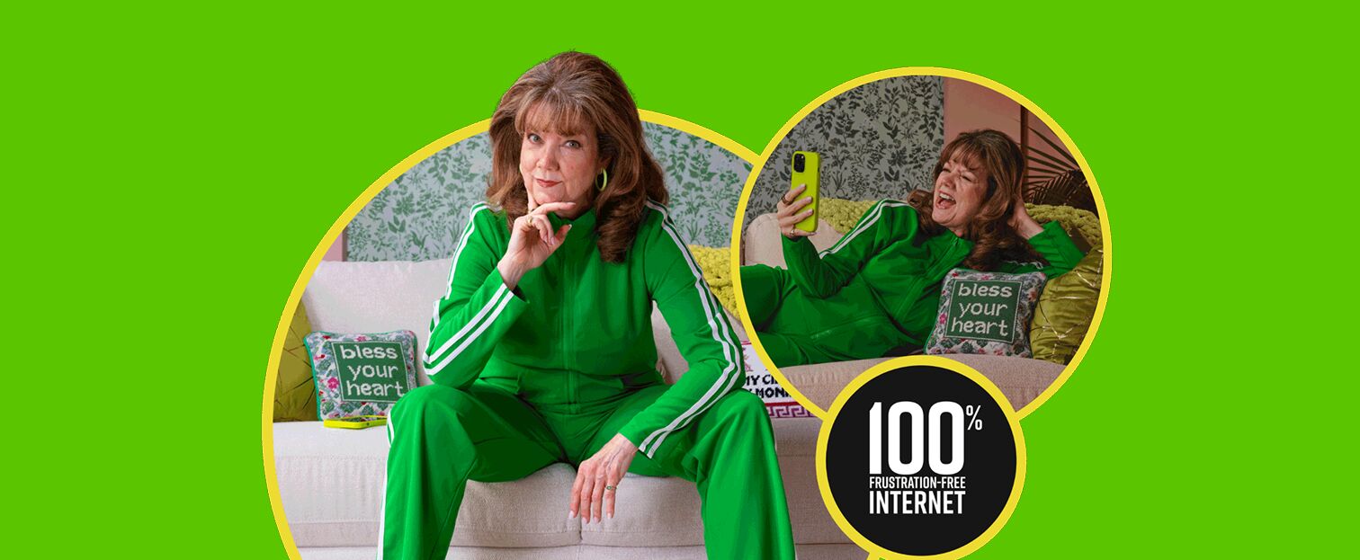An older woman in a vibrant green tracksuit is shown in two poses on a white couch. In the left image, she is sitting upright, looking at the camera with her hand on her chin. In the right image, she is lying on the couch, holding a yellow smartphone and laughing while taking a selfie. A pillow with the text "bless your heart" is visible in both images. A circular graphic in the lower right corner displays "100% FRUSTRATION-FREE INTERNET". The scene is set against a bright lime green background with decorative wallpaper visible behind the couch.