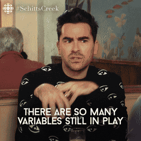 David Rose from Schitt's Creek, wearing a black sweater patterned with eyes, looks anxious and gestures with his hands as the text overlay says, 'THERE ARE SO MANY VARIABLES STILL IN PLAY.'